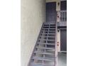 Exterior staircase that provides access to the upper level of the property with a tan stucco wall at 2624 Hidden Lake Dr N # C, Sarasota, FL 34237