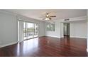 Bright living room featuring hardwood floors, a ceiling fan, and sliding glass doors to a balcony at 2901 26Th W St # 312, Bradenton, FL 34205