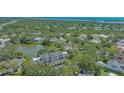 Aerial view of the property showcasing its proximity to a serene pond and lush green surroundings at 33 Bishops Court Rd # 118, Osprey, FL 34229