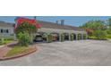 A multi-car carport shows parking for residents, surrounded by lush green landscaping at 33 Bishops Court Rd # 118, Osprey, FL 34229