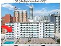 Condo building with pool and lounge chairs with building in sunny location at 33 S Gulfstream Ave # 502, Sarasota, FL 34236
