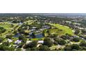 Aerial view of an expansive community, golf course, tennis courts, and ponds, showcasing the property's prime location at 3362 Charles Macdonald Dr, Sarasota, FL 34240