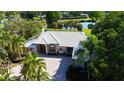 Stunning home with a paver driveway and lush landscaping, with golf course and pond views in the background at 3362 Charles Macdonald Dr, Sarasota, FL 34240
