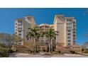 Elegant condo building featuring multi-story design, portico entrance, and lush palm trees at 385 N Point Rd # 503, Osprey, FL 34229