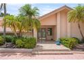 Inviting front entrance with double doors, complemented by lush landscaping and stone steps at 3936 Spyglass Hill Rd, Sarasota, FL 34238