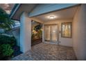 Welcoming front porch with stone flooring, double doors, and a stylish window at 3936 Spyglass Hill Rd, Sarasota, FL 34238