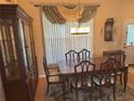 Elegant dining room with wooden table, upholstered chairs, china cabinet and decorative window at 40 Mariner Ln, Rotonda West, FL 33947