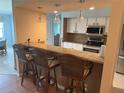 Open kitchen with a granite countertop breakfast bar, pendant lighting and stainless steel appliances at 40 Mariner Ln, Rotonda West, FL 33947