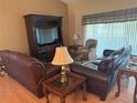 Comfortable living room with wood floors, sofas, coffee table, lamps and large windows at 40 Mariner Ln, Rotonda West, FL 33947