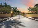 Gated entrance leading to a long private driveway and estate home with lush landscaping at 4225 Ulman Ave, North Port, FL 34286