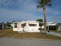 Cozy mobile home with well-maintained landscaping, carport, and inviting curb appeal in a quiet neighborhood at 5119 Glen Echo Ave, Sarasota, FL 34234