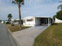 Well-kept mobile home with a long driveway, carport, and landscaped yard providing convenient parking and outdoor space at 5119 Glen Echo Ave, Sarasota, FL 34234