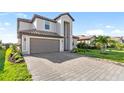 Charming two-story home with a two-car garage, nicely landscaped yard, and paver driveway under a blue sky at 5333 Coral Reef Way, Bradenton, FL 34211