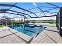 Screened pool with spa and lake views; features lounge chairs and tiled patio for relaxation and enjoyment at 5333 Coral Reef Way, Bradenton, FL 34211