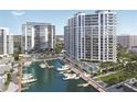 Aerial view of luxurious condos, a marina with yachts, palm trees and a beautiful pool area at 555 Quay Cmn # 801, Sarasota, FL 34236