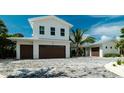 Charming home featuring a three-car garage and well-maintained landscaping for a welcoming entrance at 603 Emerald Ln, Holmes Beach, FL 34217