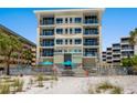 An exterior building view from the beach showcases its multiple floors, balconies, and seaside allure at 6512 Midnight Pass Rd # 303, Sarasota, FL 34242
