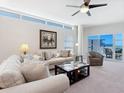 Bright living room featuring contemporary furnishings, a large window, and a balcony with ocean views at 6512 Midnight Pass Rd # 303, Sarasota, FL 34242