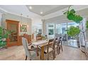 Elegant dining room with tile floors, a wine cooler, and views of the screened-in pool at 6539 Flycatcher Ln, Lakewood Ranch, FL 34202