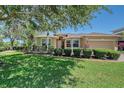 Charming home exterior with lush lawn, manicured hedges, and well-maintained landscaping at 6605 38Th E Ln, Sarasota, FL 34243