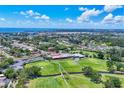 Picturesque aerial view of the golf course community with scenic water views in the distance at 6931 Magellan Way, Sarasota, FL 34243