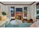 Inviting living room with a fireplace, hardwood floors, and large windows allowing natural light at 720 37Th W St, Bradenton, FL 34205