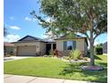 Charming single-story home featuring manicured lawn and garden beds surrounding the property at 7311 64Th St E, Palmetto, FL 34221