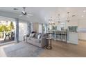 Cozy living space featuring a comfortable couch, kitchen bar, and natural light from the adjacent balcony at 799 Jacaranda Rd, Anna Maria, FL 34216