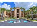 Beautiful condominium building featuring well-maintained landscaping with lush, mature palm trees at 8105 Grand Estuary Trl # 105, Bradenton, FL 34212