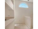 Light-filled loft featuring vaulted ceilings, a unique arched window, and a staircase with white railings at 8315 Glenrose Way # 1421, Sarasota, FL 34238