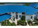 Exterior view of condo featuring a bright blue roof and well-maintained landscaping at 939 Sandpiper Cir, Bradenton, FL 34209