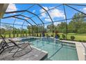 Stunning screened-in pool and jacuzzi area with comfortable lounge chairs, perfect for relaxation at 9769 Highland Park Pl, Palmetto, FL 34221