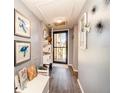 Entry hallway with calming gray walls, wood floors, and tasteful decorations at 104 Capri Isles Blvd # 207, Venice, FL 34292