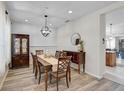 Cozy dining room with stylish chandelier, wood floors, and decorative china cabinet at 12149 Forest Park Cir, Bradenton, FL 34211