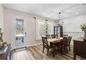 Elegant dining room with stylish chandelier, wood floors, and ample natural light from door and window at 12149 Forest Park Cir, Bradenton, FL 34211