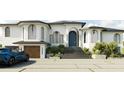 Stunning exterior view of a two-story home with a black roof, blue front door, and a 3-car garage at 1384 Harbor Dr, Sarasota, FL 34239