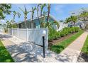 Beautiful exterior view of the home with a white fence and manicured landscaping at 170 Roosevelt Dr # 2, Sarasota, FL 34236