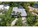 Aerial view of home with tile roof, screened pool, palm trees and meticulous landscaping near a pond at 1780 Pine Harrier Cir, Sarasota, FL 34231