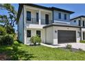 Modern two-story home with a driveway, dark garage door, and minimalistic landscaping at 2335 Oak Ter, Sarasota, FL 34231