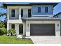 Contemporary two-story home with a dark garage door, complemented by a well-maintained lawn at 2335 Oak Ter, Sarasota, FL 34231