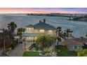 Stunning waterfront home boasts panoramic views of the bay and bridge, surrounded by lush palm trees at 2438 Baywood W Dr, Dunedin, FL 34698