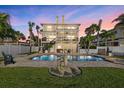 Resort-style backyard with a sparkling pool, lush landscaping, and outdoor dining area, perfect for entertaining at 2438 Baywood W Dr, Dunedin, FL 34698