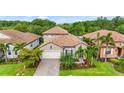 Charming single-Gathering home with a well-manicured lawn, paver driveway, tile roof, and tropical landscaping at 2745 62Nd E Ave, Ellenton, FL 34222