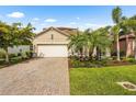 Well-maintained single-Gathering home with a two-car garage, paver driveway, and lush lawn at 2745 62Nd E Ave, Ellenton, FL 34222