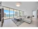 Bright living room featuring floor-to-ceiling windows, a large sectional sofa, and elegant decor and furniture at 301 Quay Commons Dr # 1711, Sarasota, FL 34236