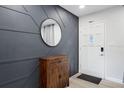 Stylish entryway featuring decorative wall paneling, modern mirror, and white front door at 3303 32Nd W St, Bradenton, FL 34205