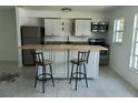 Bright kitchen features stainless appliances, white cabinets and an island with seating at 4444 Swift Rd # 14, Sarasota, FL 34231