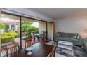 Comfortable living room with dining space and patio access, featuring a blue sofa and area rug at 4621 Gulf Of Mexico Dr # 2F, Longboat Key, FL 34228