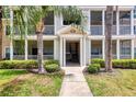 Close up shot of a condominium building entrance framed by palm trees and manicured shrubbery at 4802 51St W St # 1711, Bradenton, FL 34210