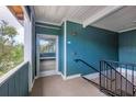 View of a condo hallway with textured teal walls and black railings at 4802 51St W St # 1711, Bradenton, FL 34210